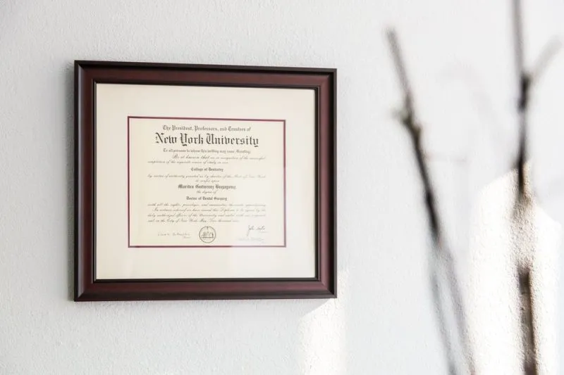Photo of Dr. Marie Bugayong's framed diploma hanging in a white wall